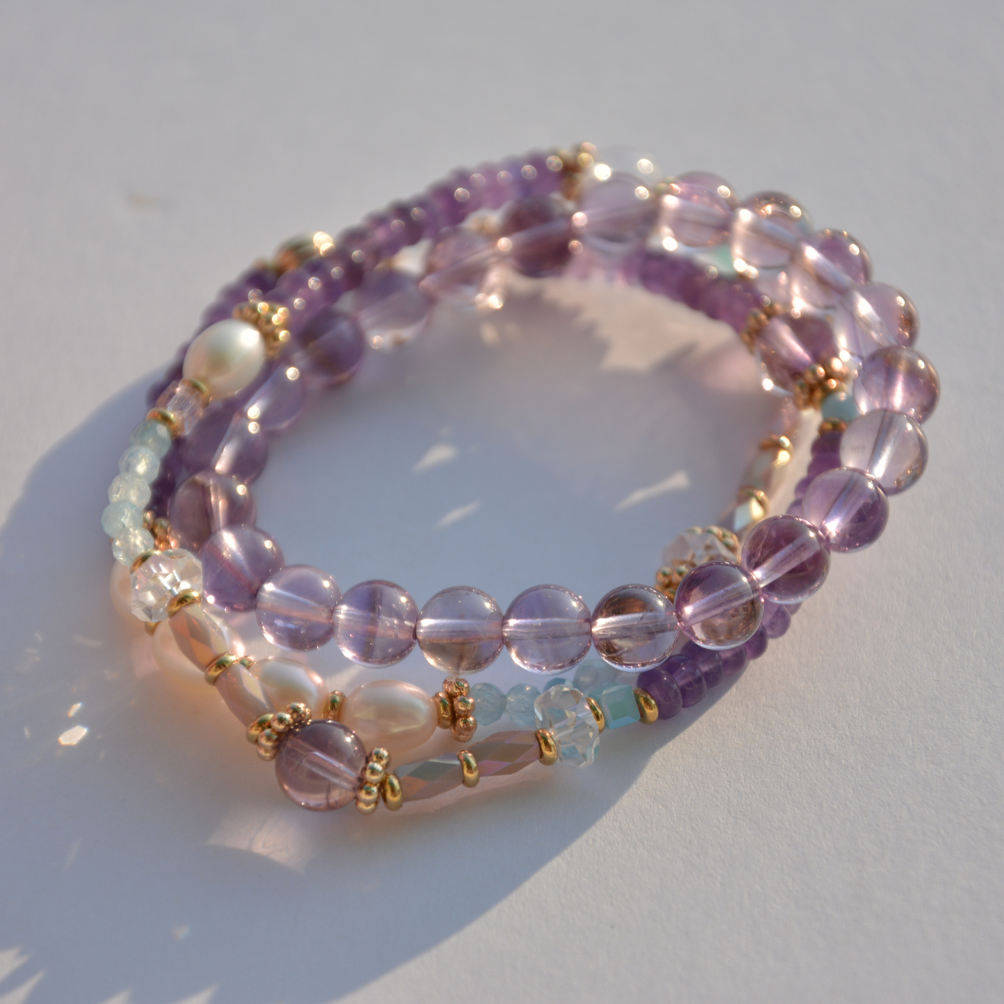 Handcrafted Double strip Amethyst Bracelets set with Brazilian Amethyst and Pearl strands, accented with Swarovski Crystals and gold-plated beads, perfect for stacked styling